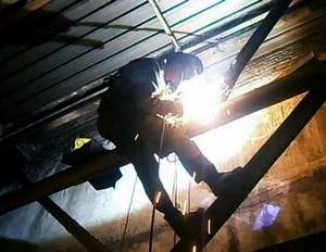 сварщик альпинист проводит работы по сварке новых конструкций